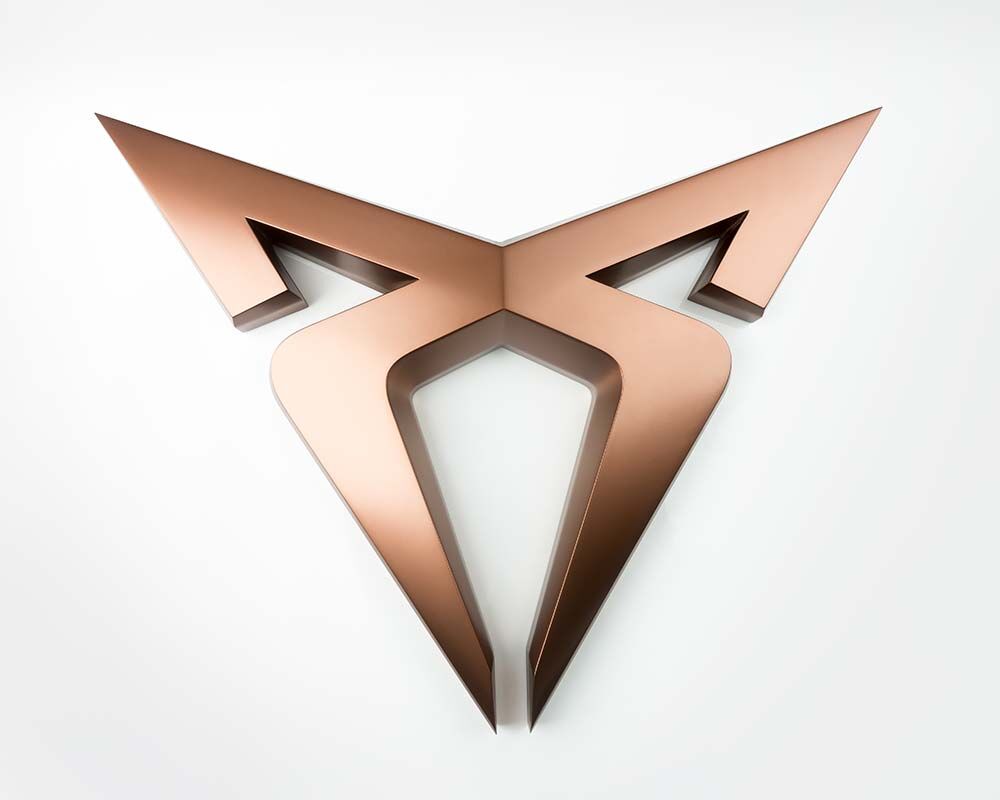 Abstract copper-colored 3D logo shaped like a stylized bull head on a white background